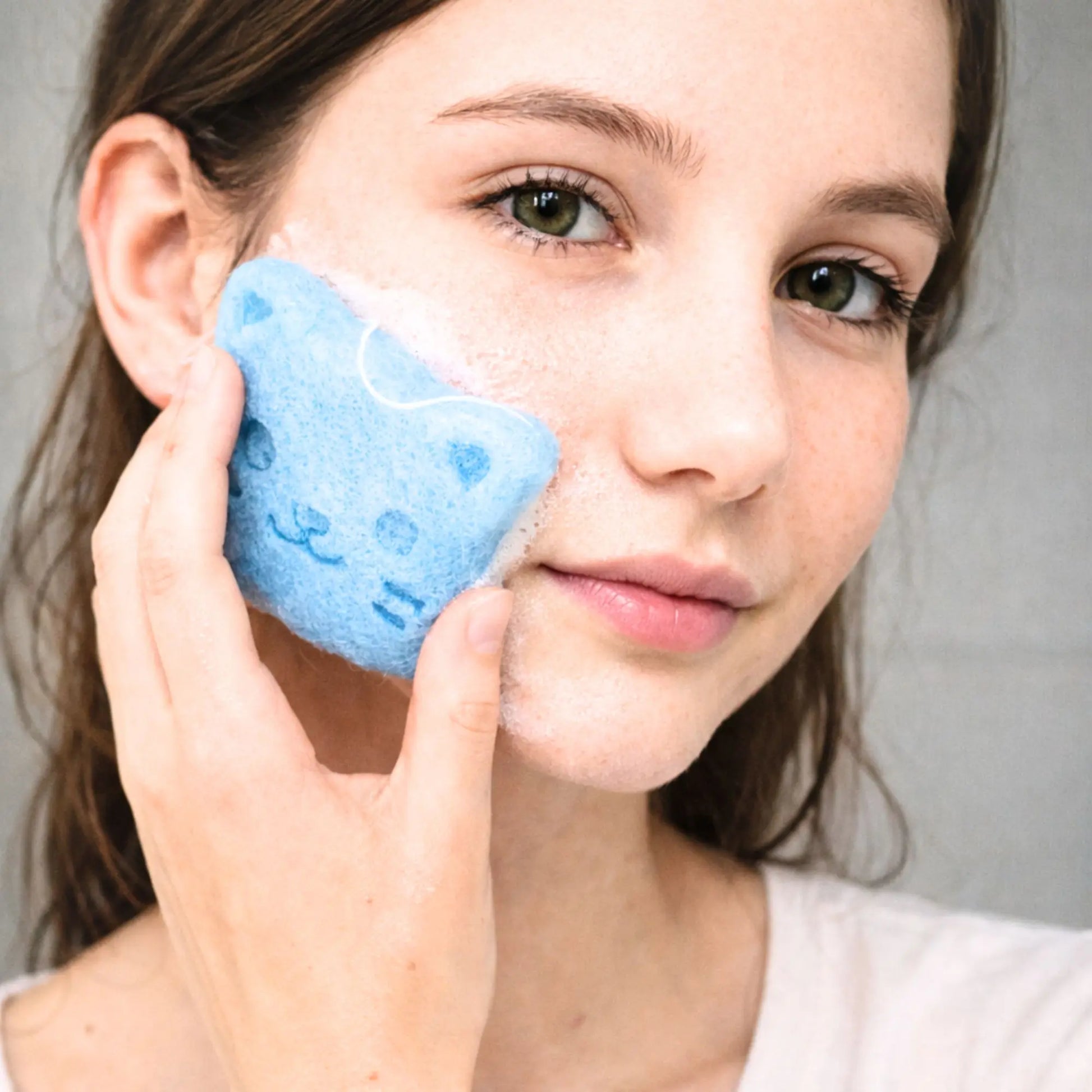 Gesichstpflege mit blauem Konjacschwamm in Katzenform