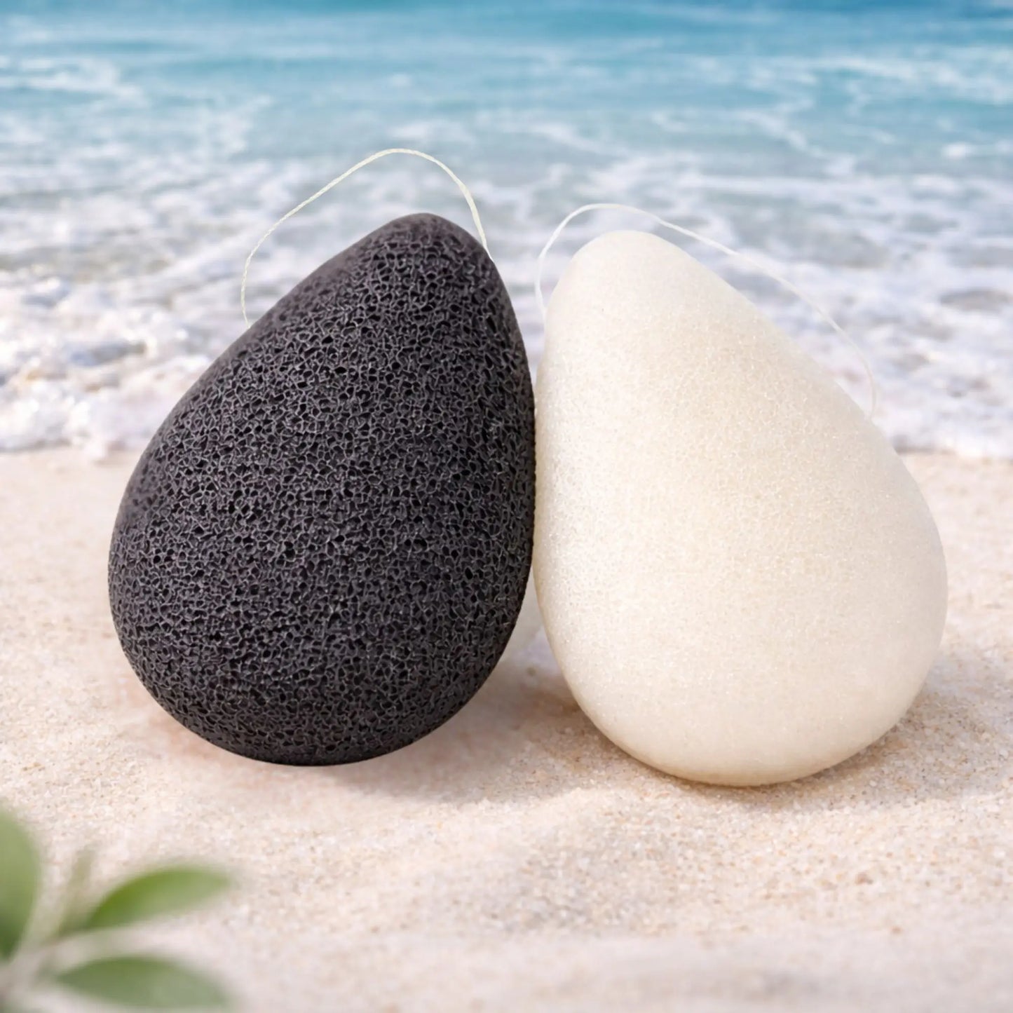 Konjacschwamm Duo Black and White in Tropfenform am Strand